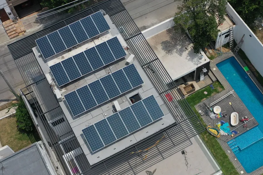 Paneles solares en la azotea de una residencia con alberca