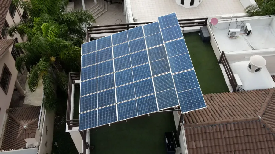 Paneles solares montados sobre una pérgola en el patio de una casa